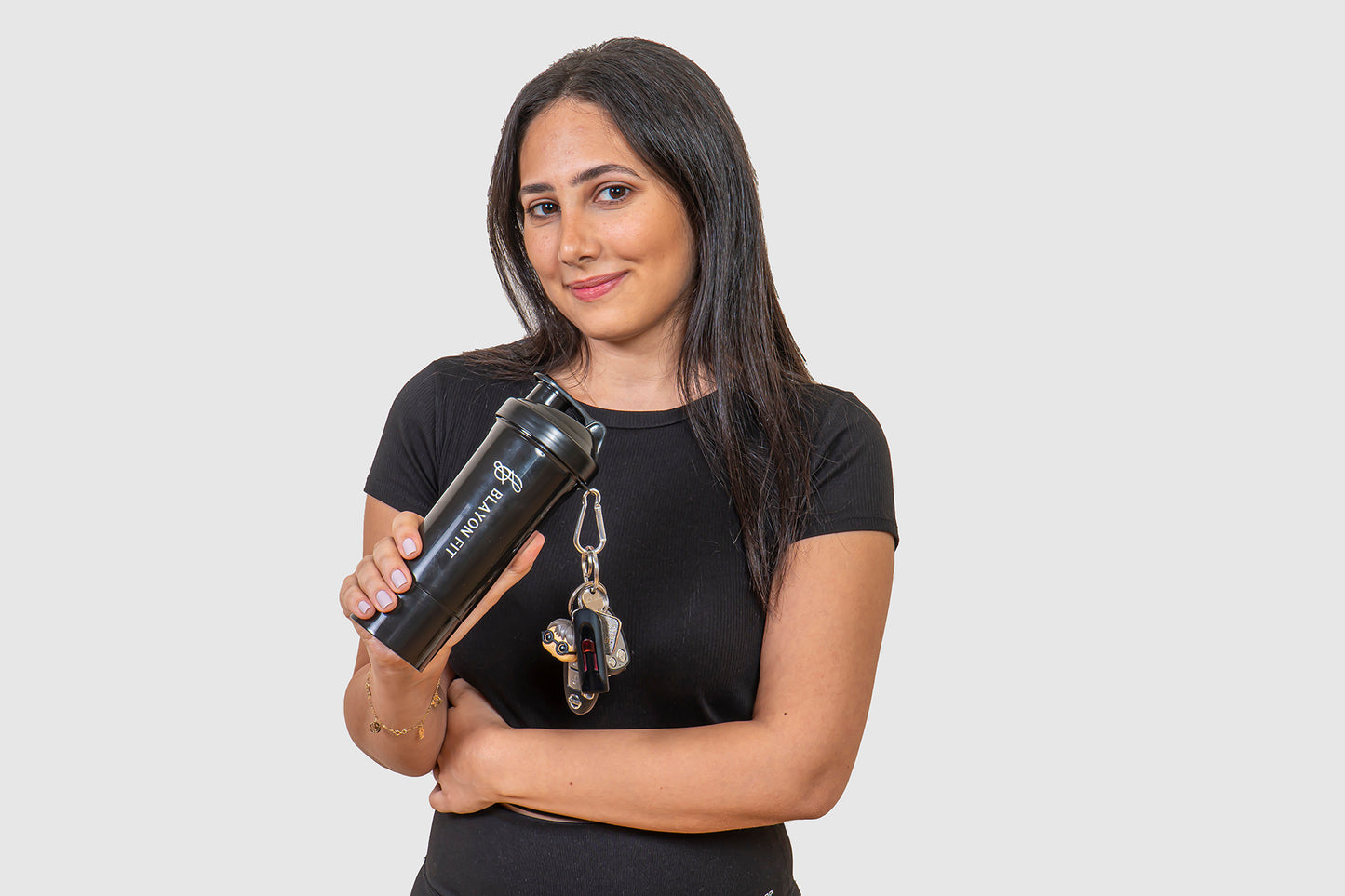 woman holding a protein shaker that is high quality and has a storage for supplements. 