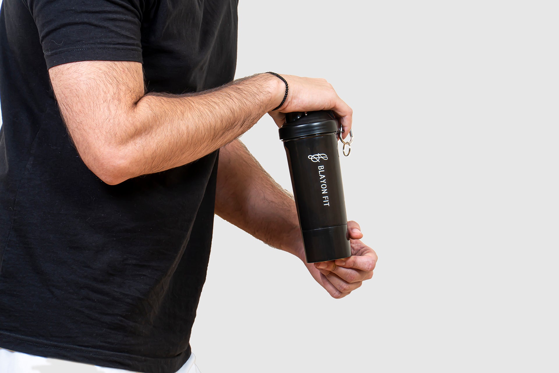 man shaking the protein shaker for a post workout meal. 